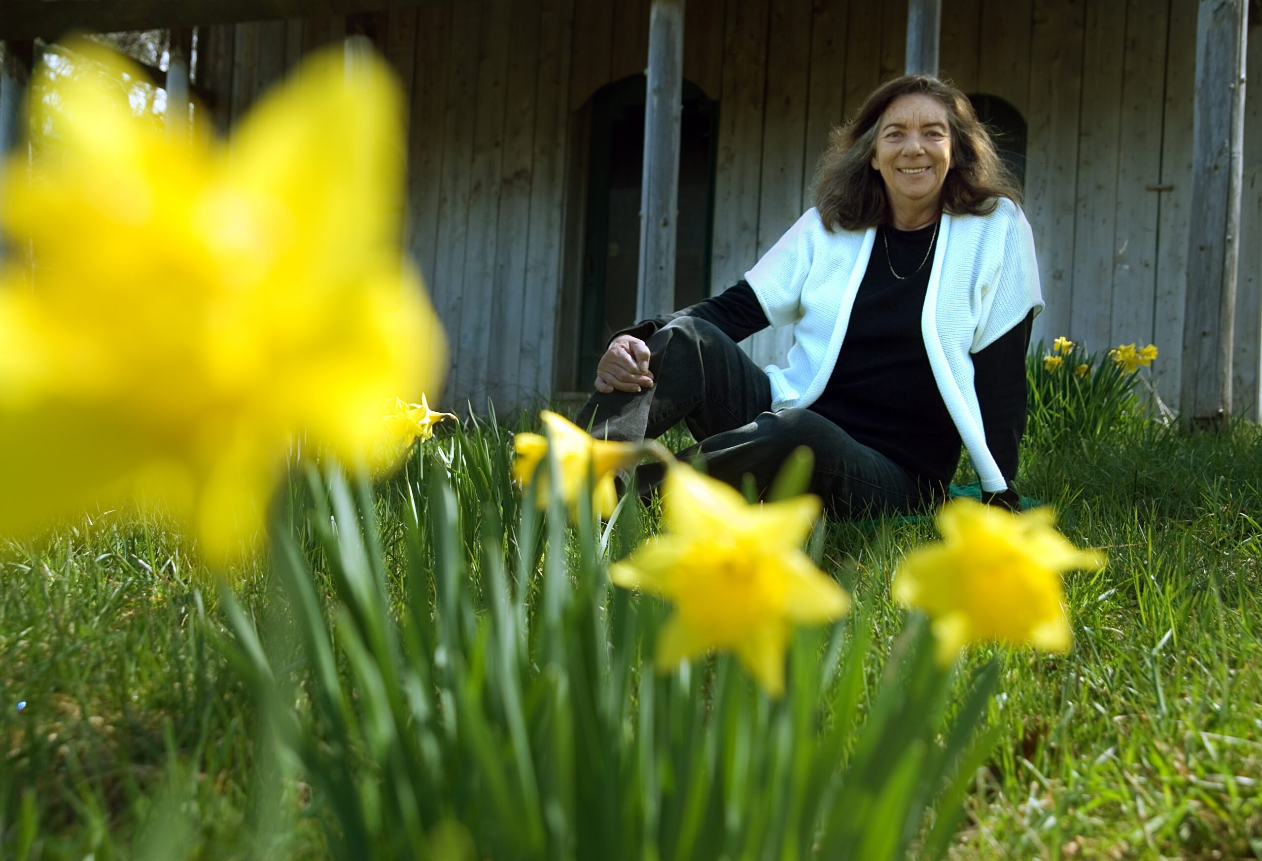 Mary Graham sitting in a field of daffodils.