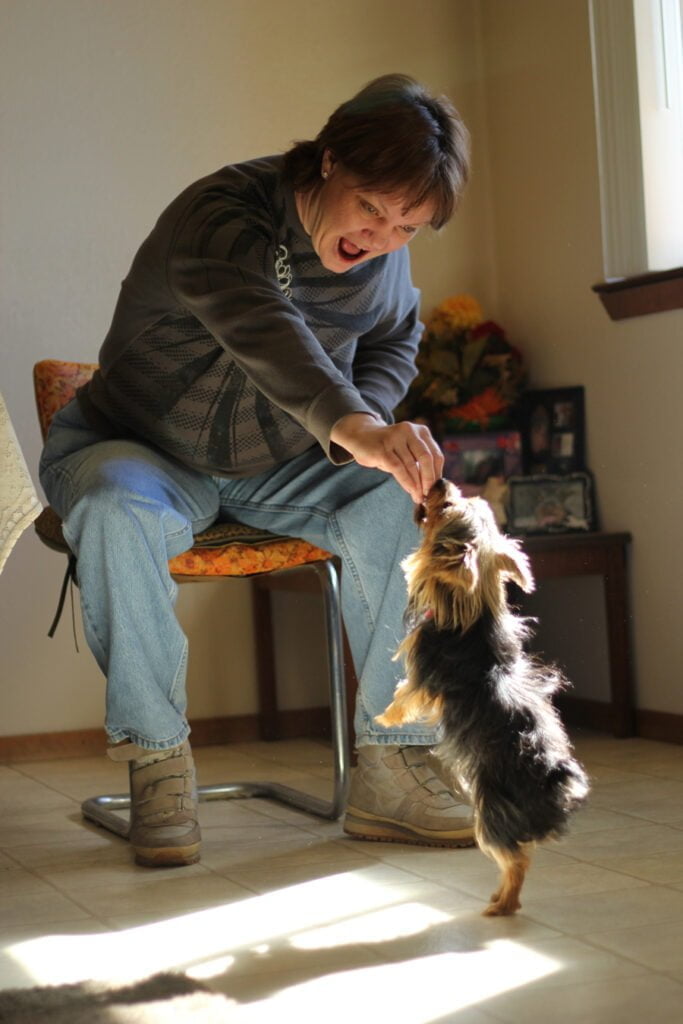 Portrait of Kristen McChristian playing with service dog.